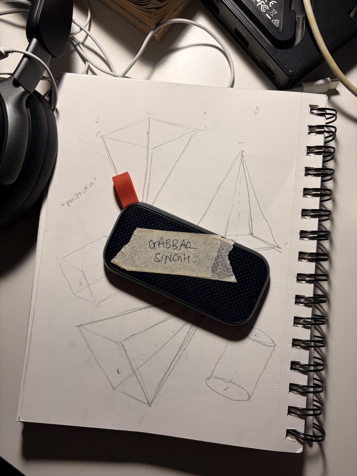 Sketchbook and an SSD labelled Gabbar Singh on a desk